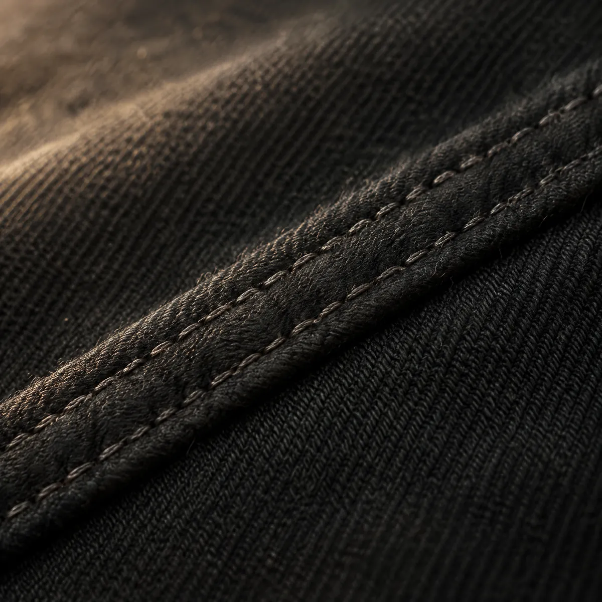 Macro view of a flat-felled seam on cotton twill.