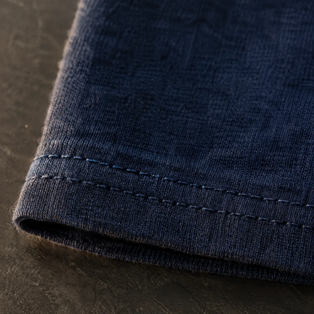 Macro view of twin-needle stitching on a T-shirt hem.