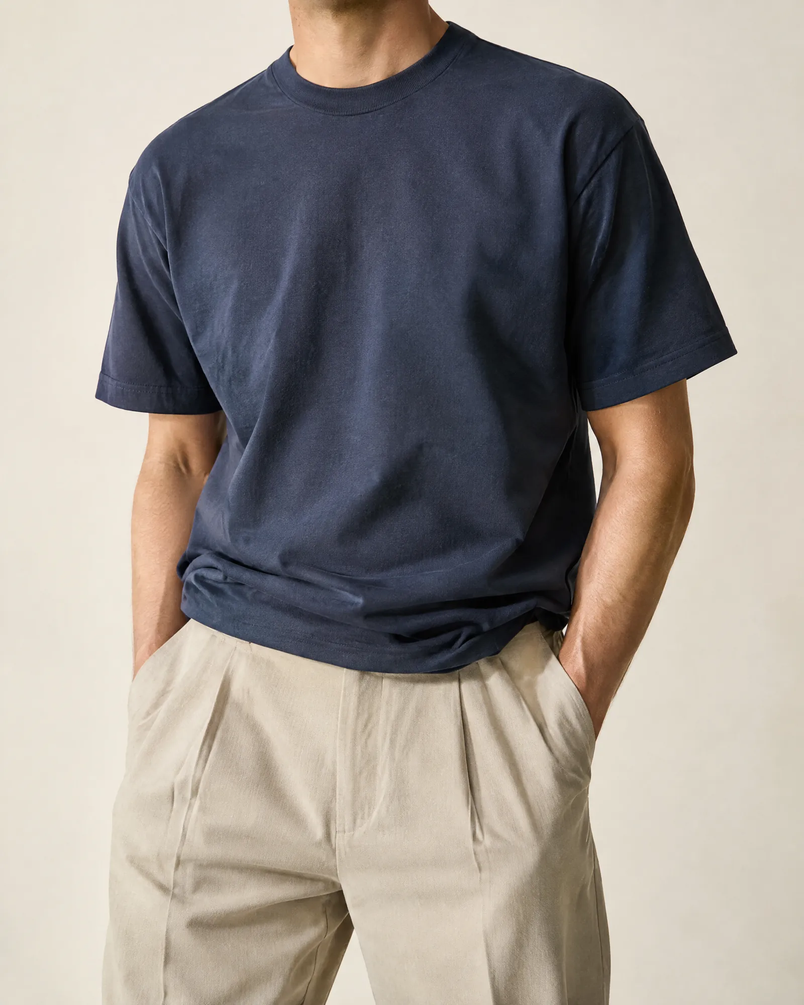 The finished deep indigo heavyweight cotton T-shirt in a minimal studio.