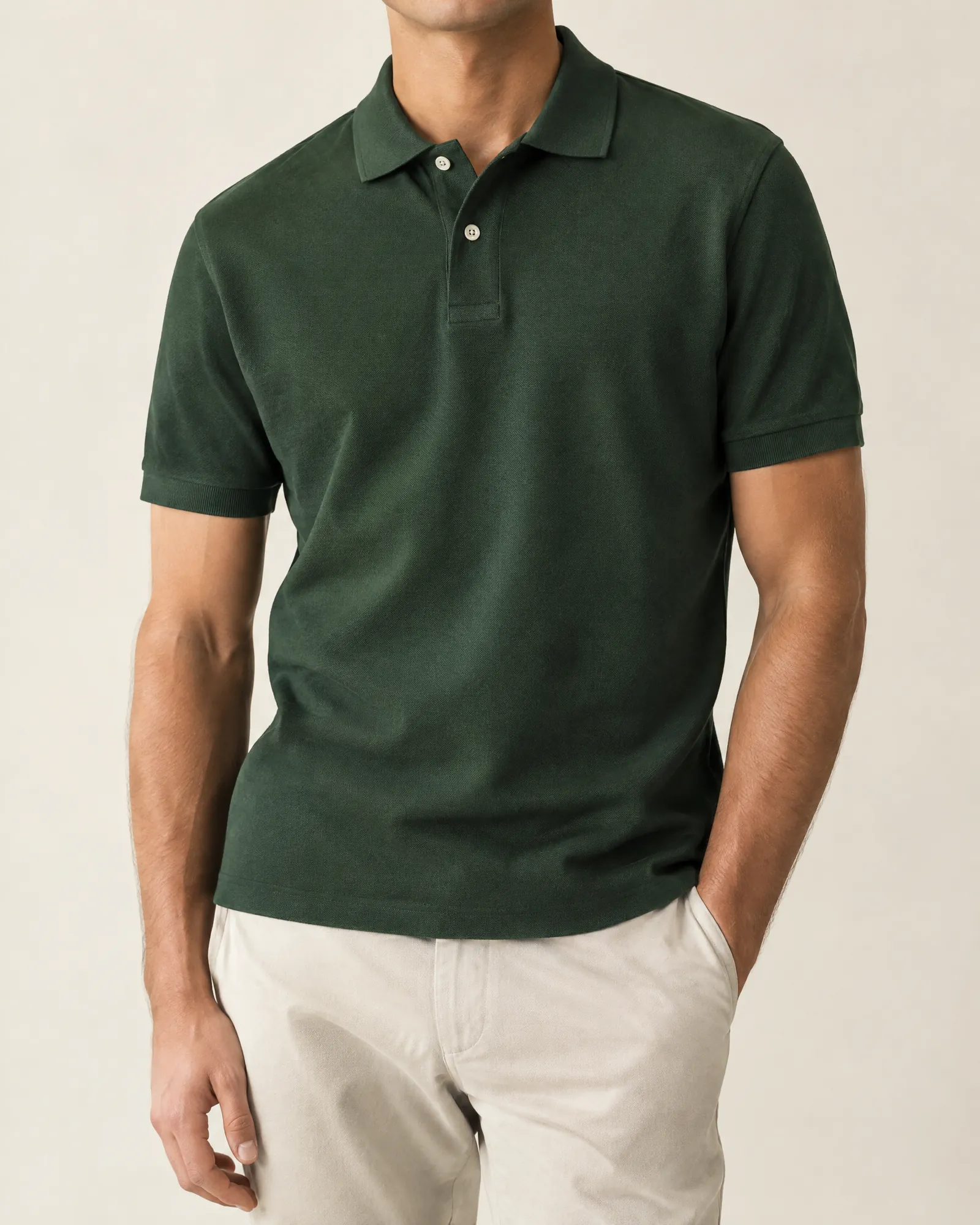 A bottle-green cotton piqué polo shirt in a minimal studio.