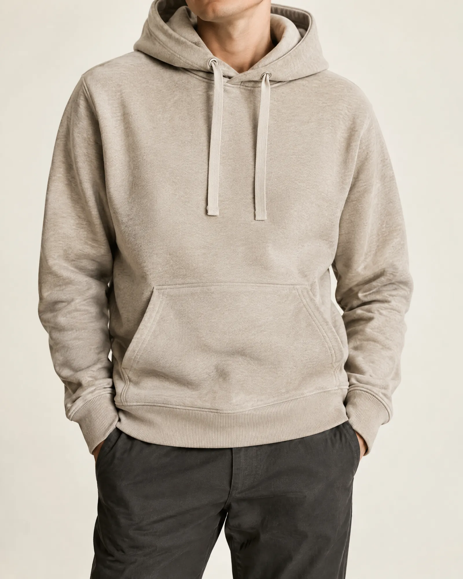 A heavyweight oatmeal fleece hoodie in a minimal studio.