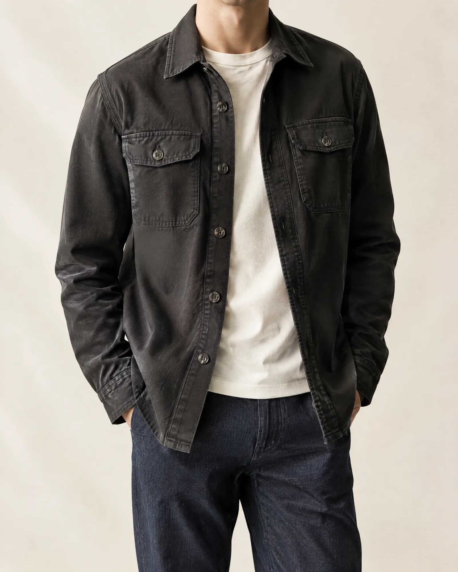 A charcoal cotton-twill overshirt in a minimal studio.